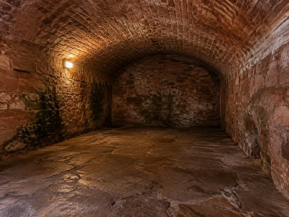 Eine kahle Steinkammer unter der South Bridge, schwach beleuchtet